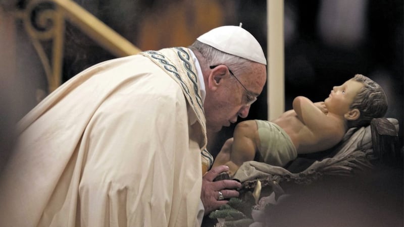 Pope Francis kisses a statue of the baby Jesus in St Peter&#39;s Basilica at the Vatican. Christmas recalls how the Lord became part of his creation, allowing himself to become a baby as he set out on his salvation mission. Picture by AP Photo/Alessandra Tarantino 