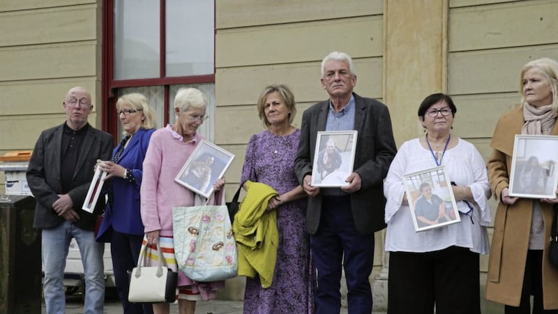 Families hold photos of their loved ones outside the first public session of an inquiry into Muckamore Abbey Hospital. Picture by Hugh Russell 