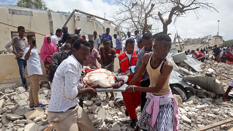 Rescuers carry away a dead body following a blast outside a district headquarters in the capital Mogadishu, Somalia today. Picture by&nbsp;Farah Abdi Warsameh, AP Photo