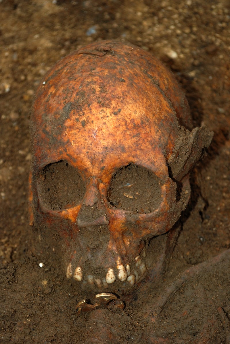 The Trumpington Cross visible below the skull of the young woman. (University of Cambridge Archaeological Unit/ PA)