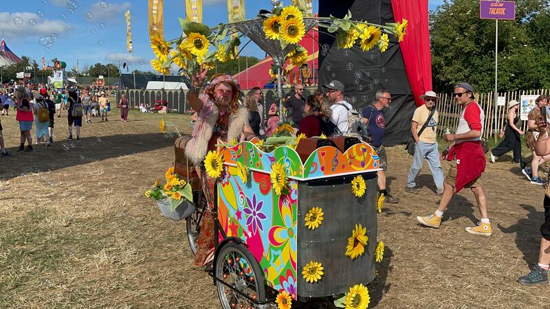 Festival goer with sunflower printed bike at Glastonbury