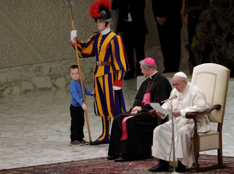 The child looks back at the audience in the Vatican hall