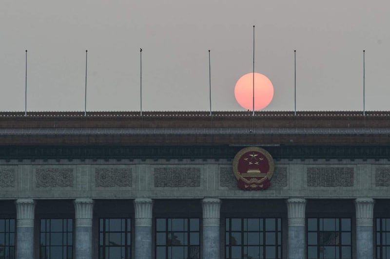 The sun sets over the Great Hall of the People on Tiananmen Square in Beijing (Stefan Rousseau/PA)