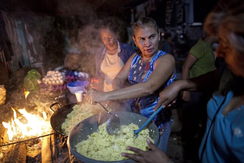 Women cook dinner for Honduran migrants at a makeshift shelter in Ciudad Hidalgo, Mexico, on October 29 2018. Picture by Rodrigo Abd, Associated Press 