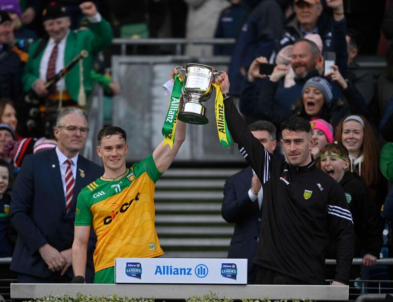 Donegal’s Ciaran Thompson and Patrick McBrearty accept the Division Two winners' trophy from Jarlath Burns. Picture Mark Marlow