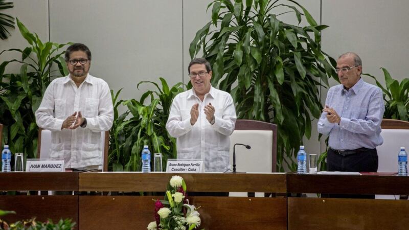 Ivan Marquez, chief negotiator of the Revolutionary Armed Forces of Colombia, or FARC, from left, Cuba's Foreign Minister Bruno Rodriguez, and Humberto de La Calle, head of Colombia's government peace negotiation team, applaud after the signing of the latest text of the peace accord between the two sides in Havana, Cuba. Picture by Desmond Boylan, Associated Press