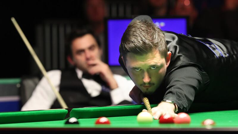 Kyren Wilson at the table on Thursday night as Ronnie O'Sullivan looks ruefully on<br />Picture by Declan Roughan &nbsp;
