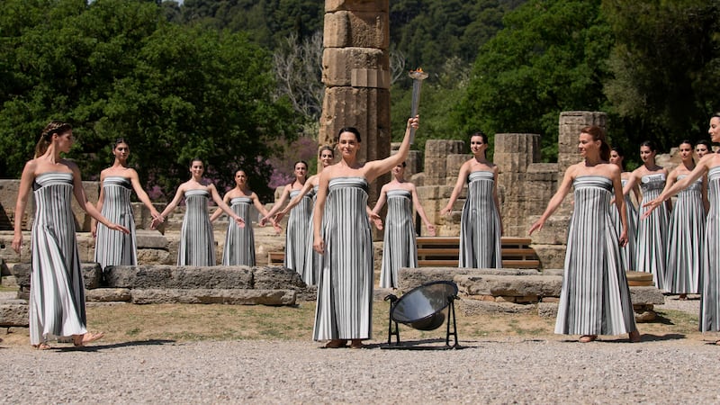 A torch is lit during the official ceremony of the flame lighting for the Paris Olympics, at the Ancient Olympia site, Greece (Thanassis Stavrakis/AP)