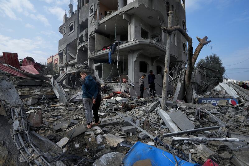 Palestinians inspect the rubble of a building destroyed in the Maghazi refugee camp (Adel Hana/AP)