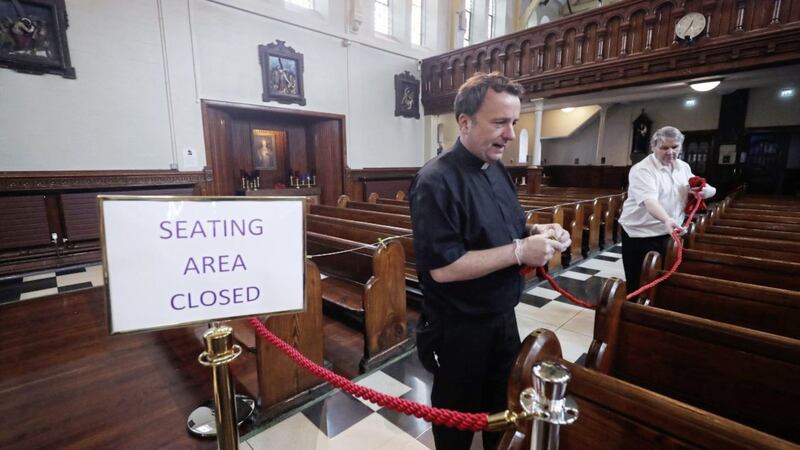 Fr Tim Bartlett and caretaker John Hanvey install Covid-19 social distancing measures at Belfast&#39;s oldest Catholic Church, St Mary&#39;s in Chapel lane, ahead of its re-opening for private prayer. A date for the resumption of collective worship in Northern Ireland has yet to be named. Picture by Niall Carson/PA Wire 