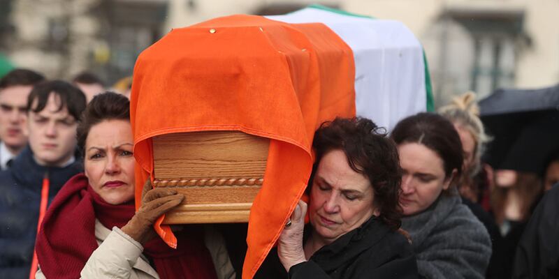 Bernie McGuinness (right), wife of Martin, carries his coffin home to the sound of applause