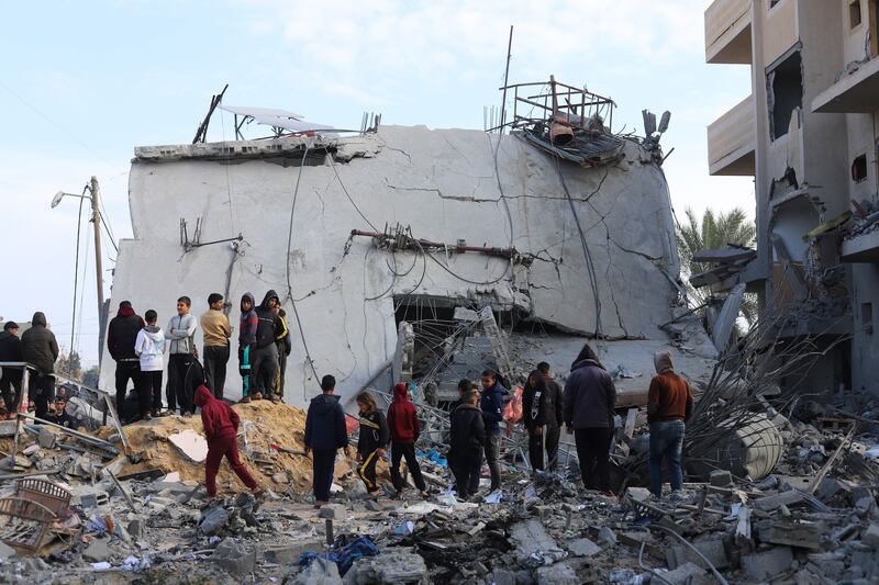 Palestinians look at the destruction after an Israeli strike on a residential building in Rafah (AP Photo/Hatem Ali)