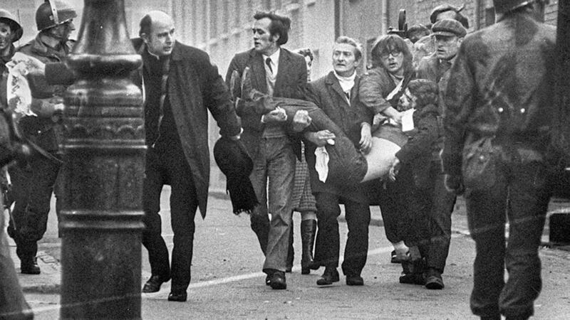 Bishop Daly helps clear a path for a man badly injured during Bloody Sunday 