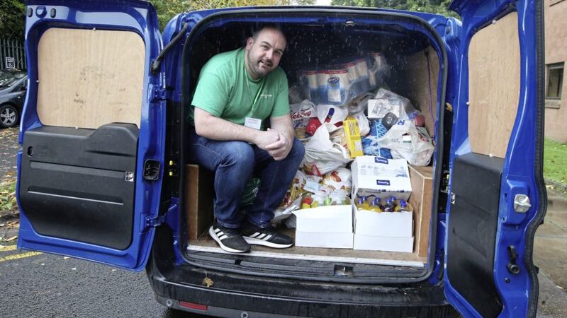 Deputy Lord Mayor Paul McCusker with just one of the donations handed in to the food bank at Farset in West Belfast Picture By Hugh Russell.