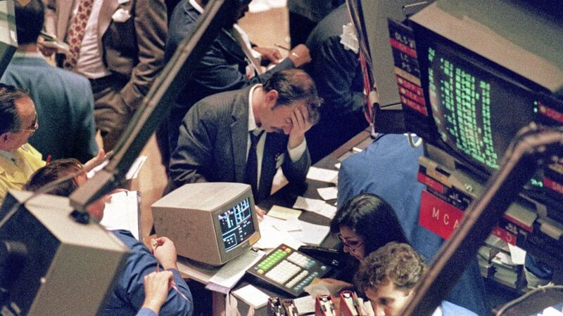 A trader holding his head at the floor of the New York Stock Exchange on Black Monday in 1987 