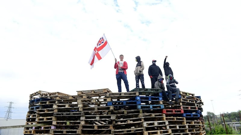 Bonfire builders atop their pyre at Avoniel Leisure Centre in Belfast earlier this week. Picture by Pacemaker/Arthur Allison 