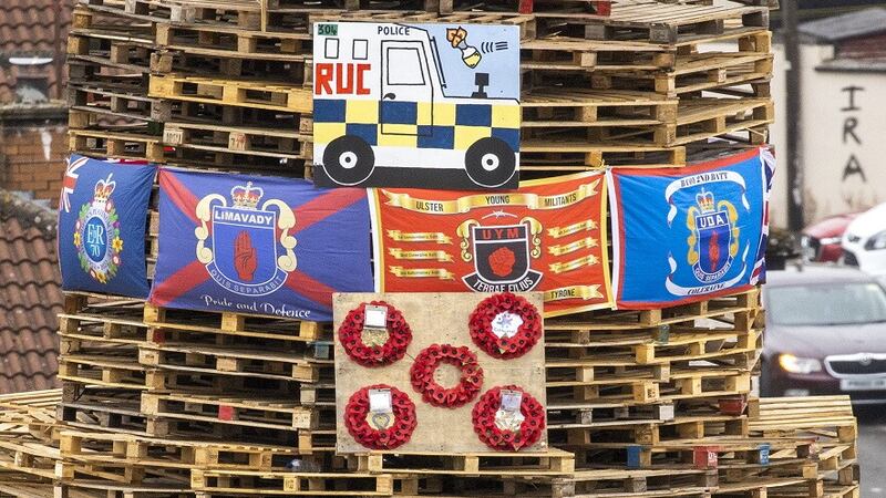 Poppy wreaths and loyalist flags on a bonfire stack prior to it being lit in the Bogside in Derry on August 15 2022