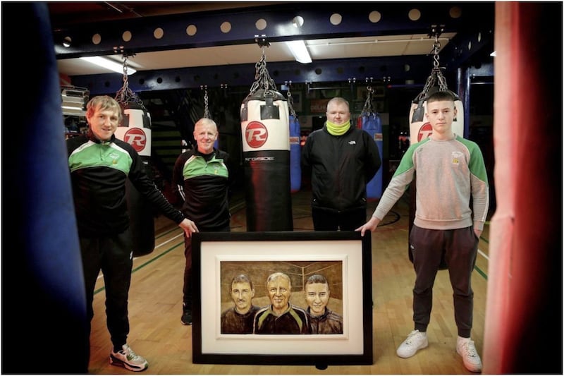 Davy and Kyle Smith with Holy Trinity coaches Michael Hawkins sr and Michael Hawkins jr at the presentation of a piece of artwork crafted by Kyle's great uncle, Alan Starrs. Picture by Hugh Russell