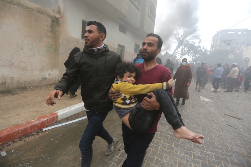 Palestinians evacuate survivors of an Israeli strike in Rafah, Gaza Strip, on Thursday (Hatem Ali/AP)