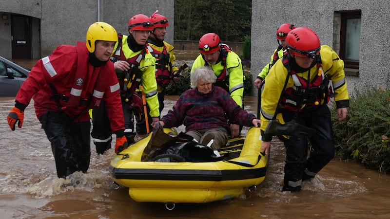 Members of the emergency services help local residents to safety in Brechin (PA)