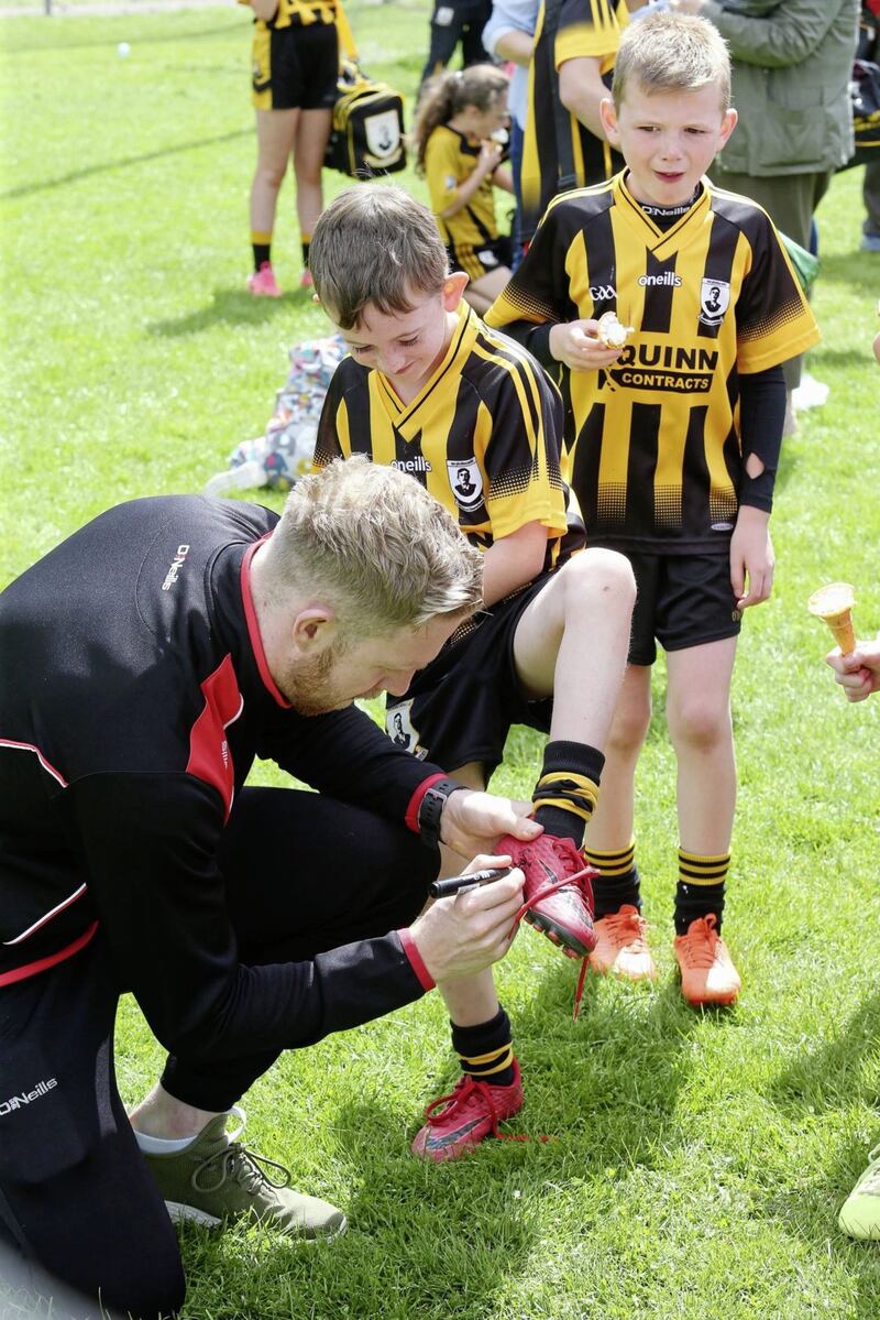 Tyrone&#39;s Frank Burns signs the boot of a young Pomeroy fan at a GAA summer camp. Picture by Mal McCann 