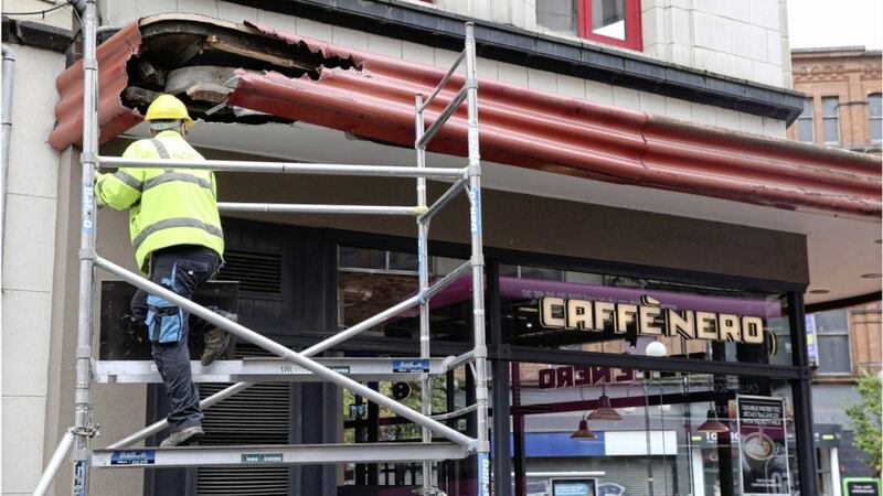 Workmen examining the damage at Caffe Nero after it was hit by a bus in Belfast. Picture by Hugh Russell 