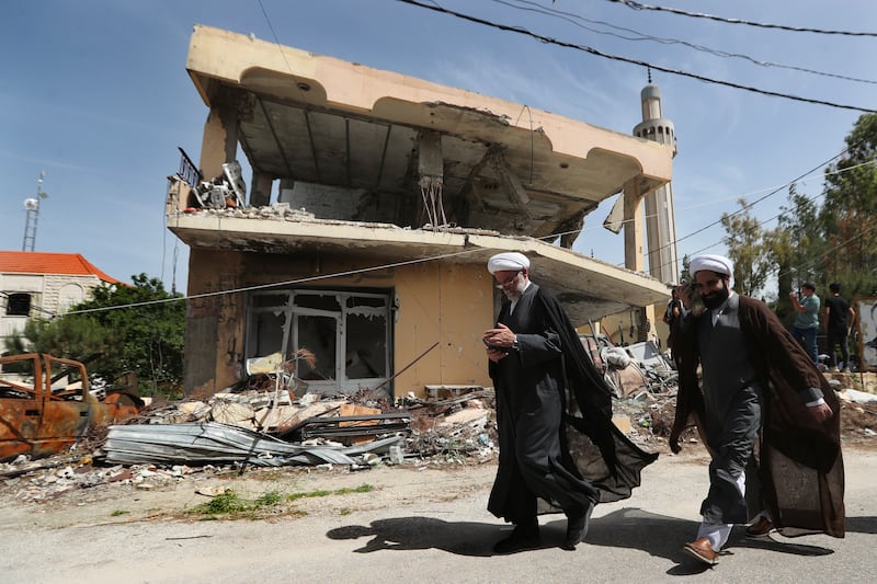 Shiite clerics pass in front of a house that was destroyed by an Israeli airstrike, in Hanine village, south Lebanon (Mohammad Zaatari/AP)