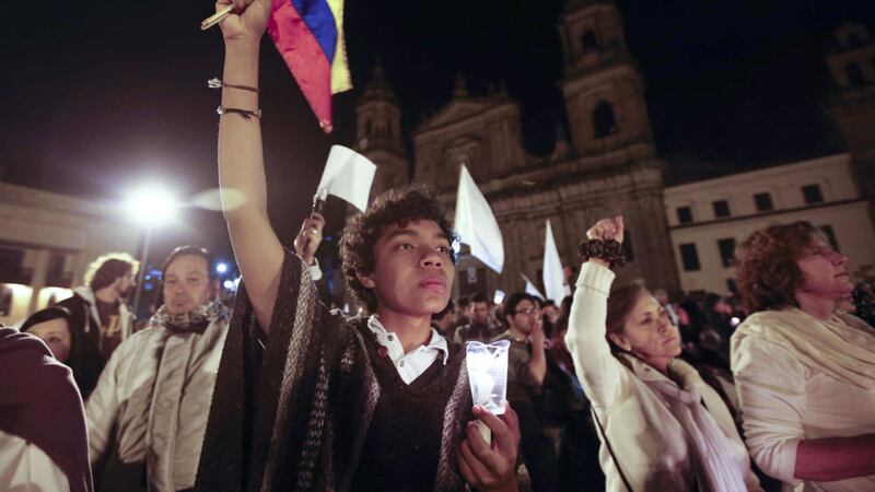 A youth holds a Colombian flag during a rally for peace in Bogota, Colombia, on Wednesday. Picture by Fernando Vergara, Associated Press
