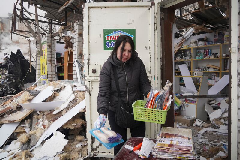 A vendor collected goods from her shop damaged by a Russian rocket attack in Kharkiv (Andrii Marienko/AP)