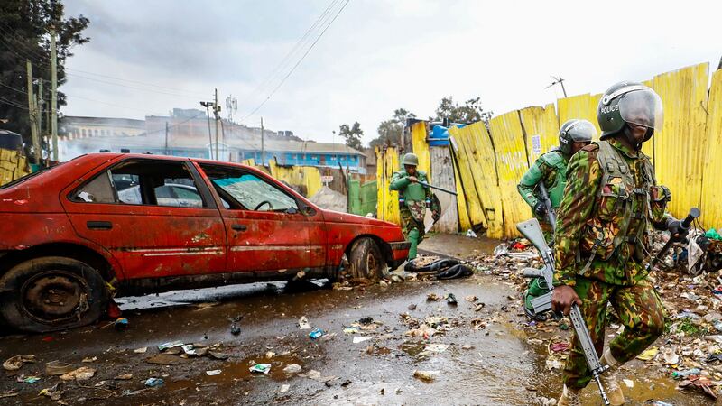 Police run towards protesters during clashes in the Kibera area of Nairobi (AP Photo/Brian Inganga)