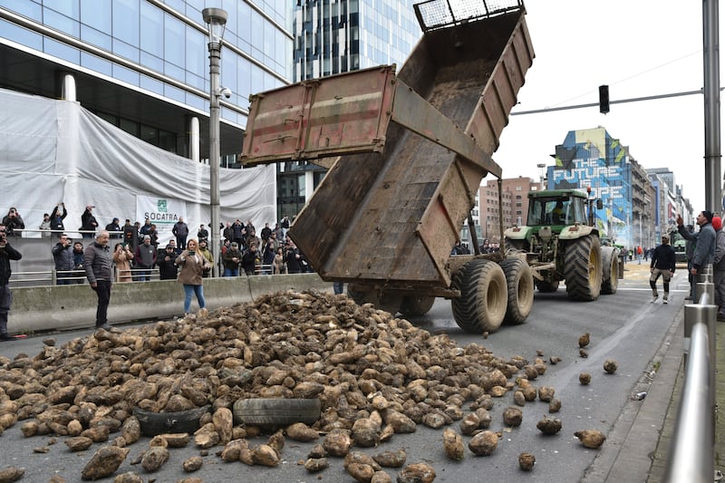 Farmers dump a load of potatoes onto a main boulevard during a demonstration outside the European Council building in Brussels (AP)