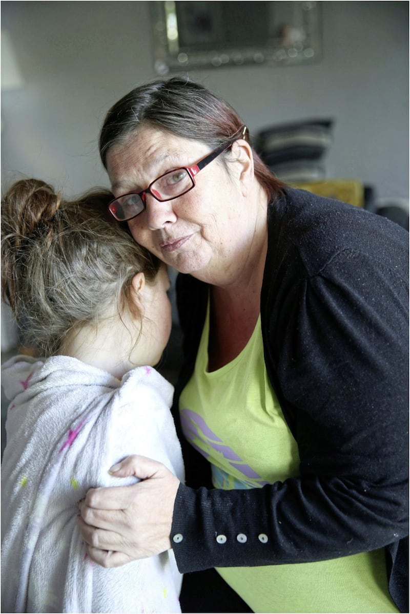 Anne-Marie O&#39;Dwyer comforts her eight-year-old grand-daughter, Annie McFadden, who suffered multiple injuries when she was mauled by a dog near her north Belfast home. Picture: Hugh Russell 