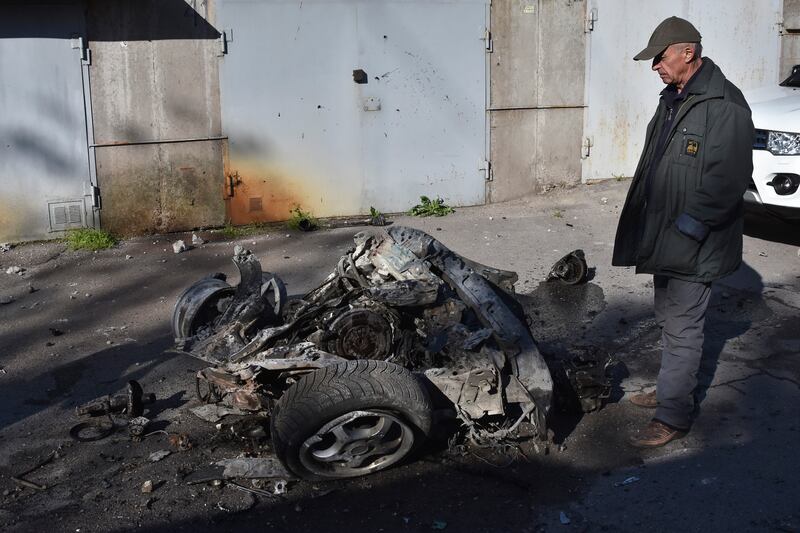 A man looks at the debris of a car following a Russian missile attack in Zaporizhzhia, Ukraine (Andriy Andriyenko/AP)