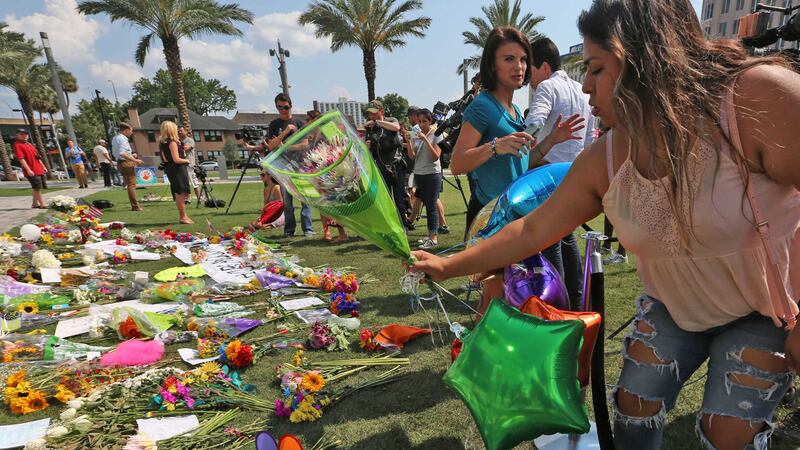 Celeste Gonzalez (18) of Ocoee, Florida, brings a bouquet of flowers to a memorial at Dr&nbsp;Phillips Center, in Orlando, for the victims of a shooting at the Pulse nightclub. Picture by&nbsp;Red Huber, Orlando Sentinel/Associated Press