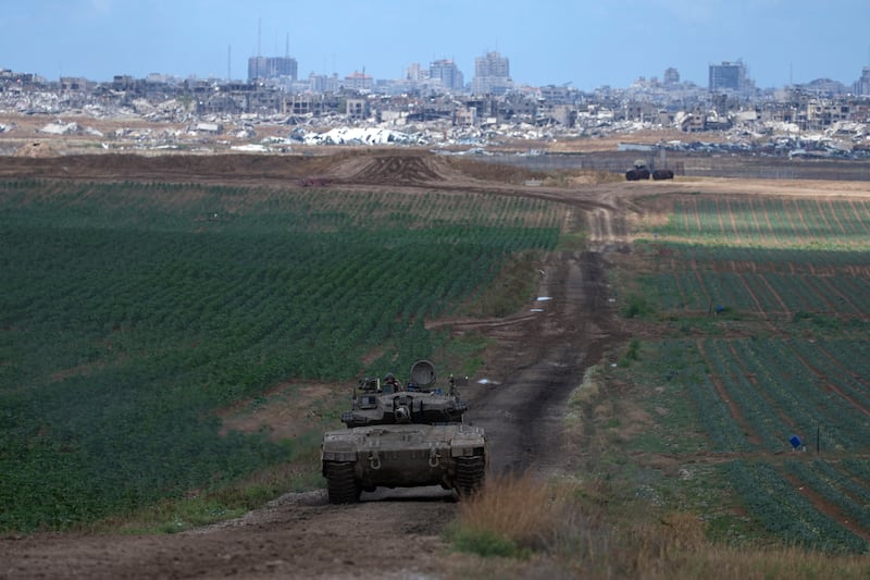 An Israeli defence force tank drives away from the Gaza Strip, as seen from southern Israel (Tsafrir Abayov/AP)