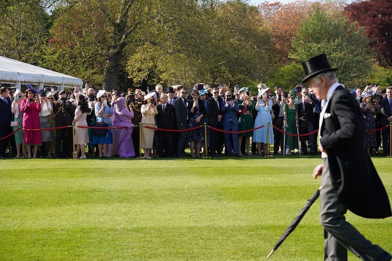 Guests watch as King Charles III walks across the lawn during a garden party at Buckingham Palace this week. Picture by Yui Mok/PA Wire