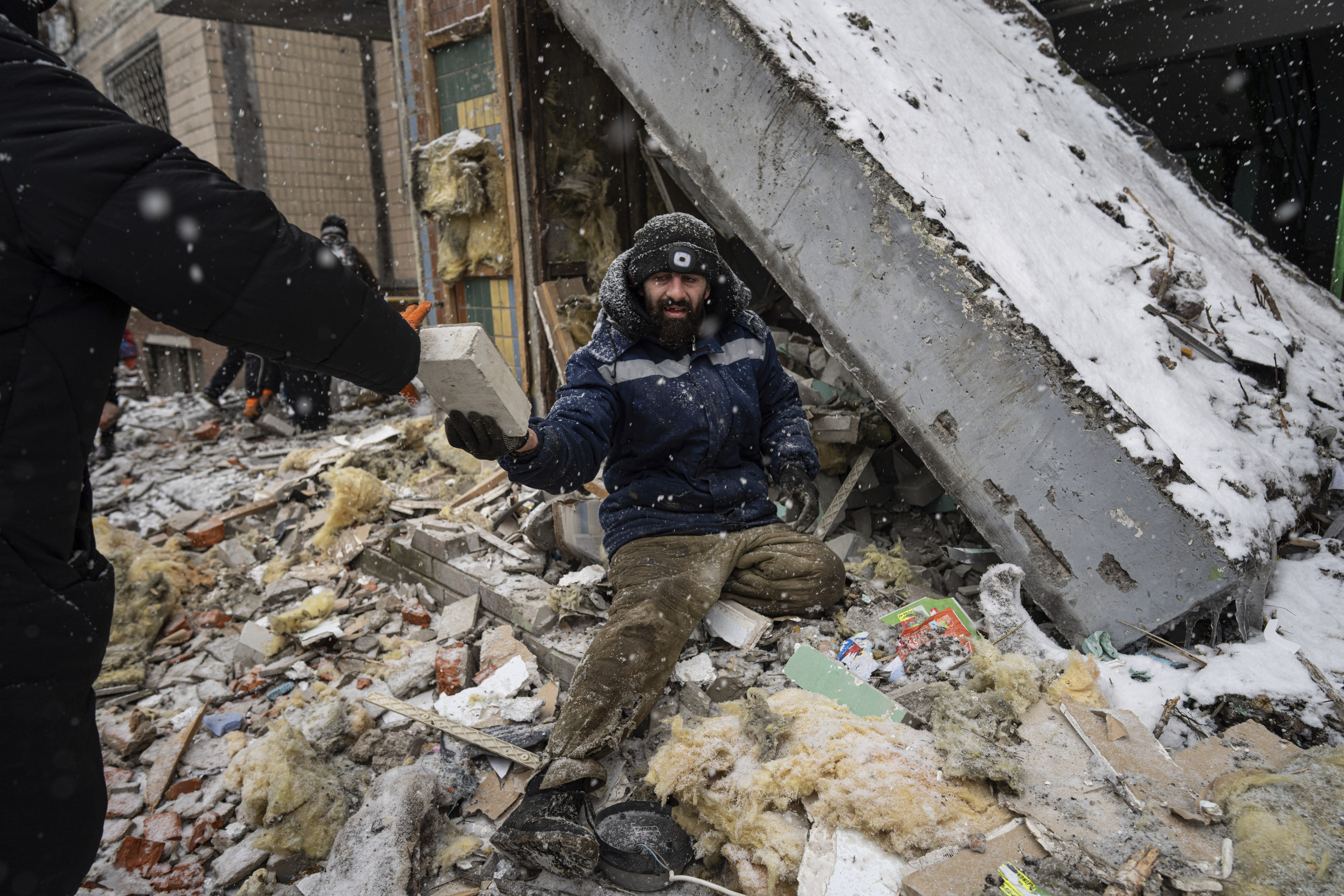 A volunteer clears the rubble of a residential building which was heavily damaged yesterday by Russian attack in Kyiv, Ukraine, during the week (AP)