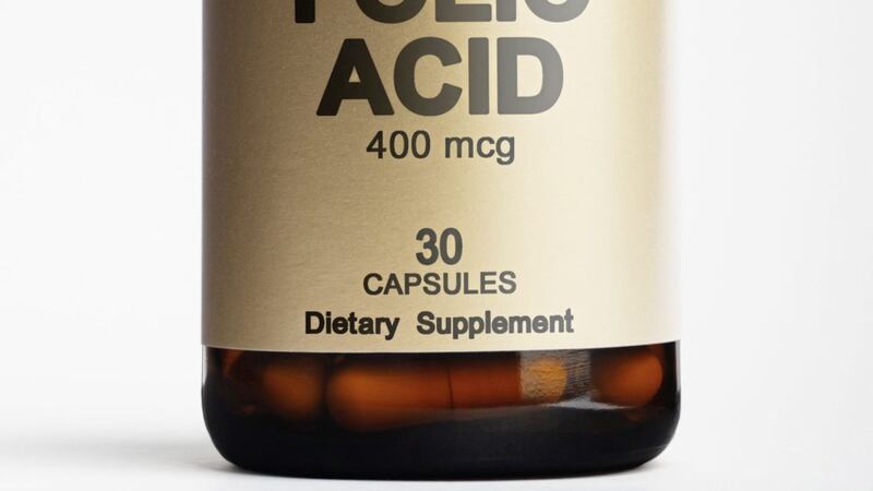 Bottle with folic acid supplement on white background 