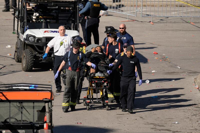 A woman is taken to an ambulance (Charlie Riedel/AP)