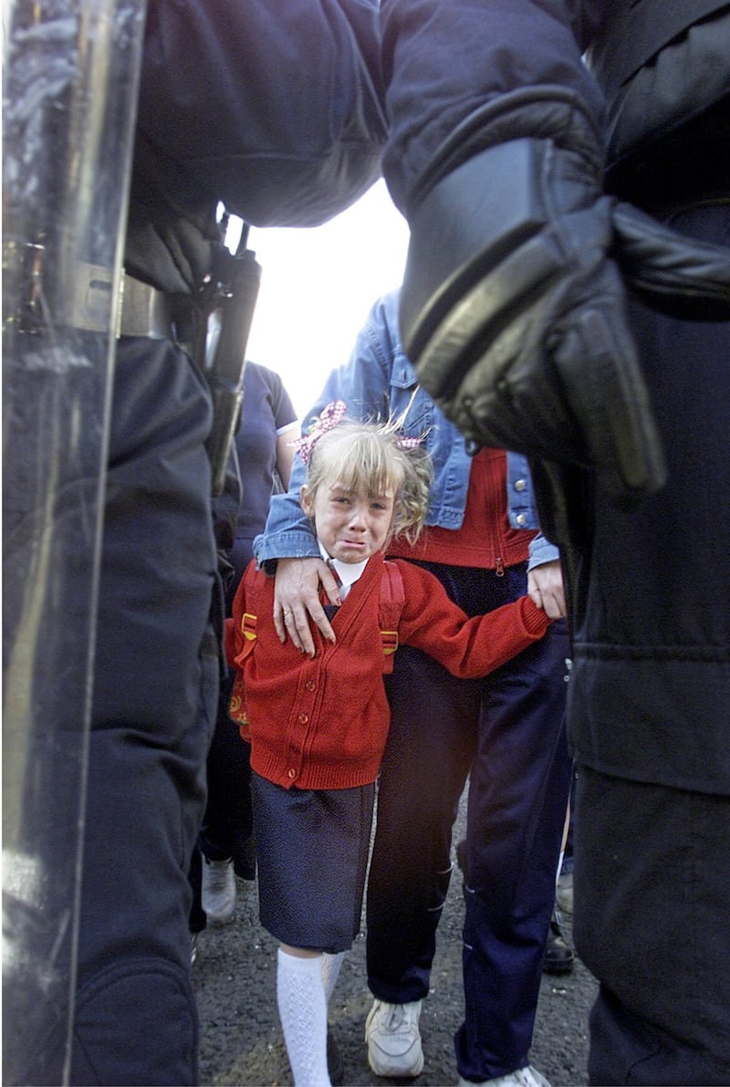A young girl on the way to Holy Cross Primary School in Ardoyne during a loyalist protest. Picture by Hugh Russell