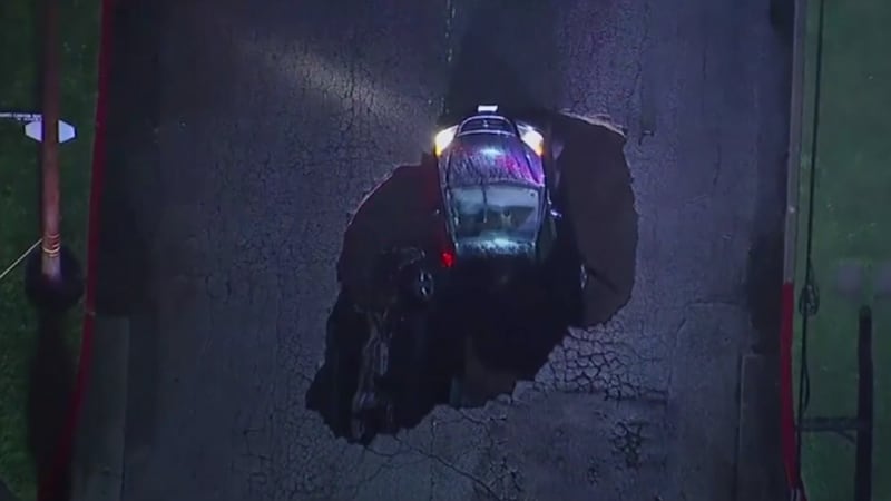 This dramatic footage shows two cars being swallowed up by a huge sinkhole in LA