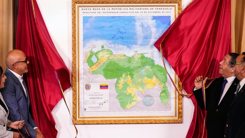 National Assembly President Jorge Rodriguez, left, and chairman of the Special Commission for the Defence of Guyana Essequibo Hermann Escarra, unveil Venezuela’s new map that includes the Essequibo territory (Matias Delacroix/AP)