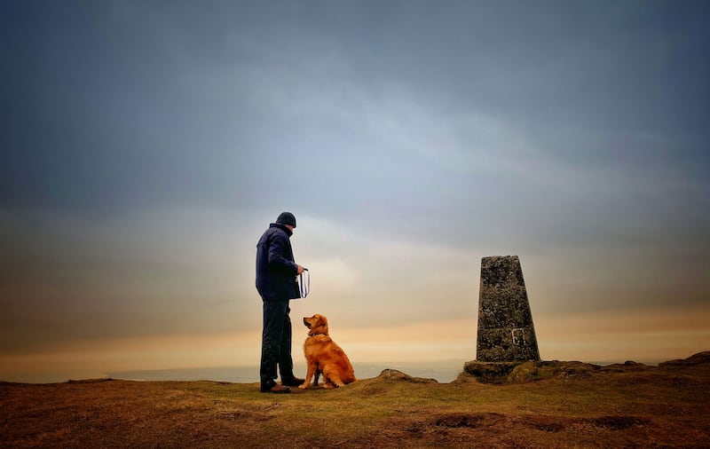 A good boy and his owner at Trig Point on Black Mountain. Picture by Mal McCann
