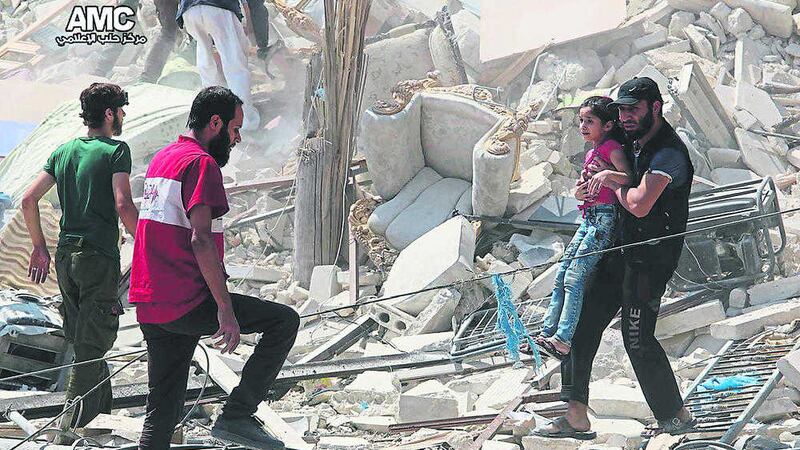 A Syrian man carries a girl away from the rubble of a destroyed building after barrel bombs were dropped on the Bab al-Nairab neighborhood in Aleppo, Syria on Saturday. Picture by Aleppo Media Center via Associated Press 
