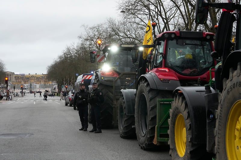 Policemen stand next to tractors parked during a protest, near the Chateau de Versailles, outside Paris, earlier in March (Michel Euler/AP)