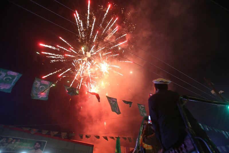 A supporter from Pakistan’s former prime minister Nawaz Sharif’s party, Pakistan Muslim League-N, watches fireworks as the party celebrates the victory of their candidate in Peshawar (AP Photo/Muhammad Sajjad)