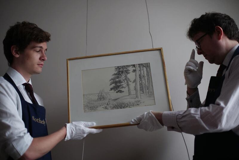 Sotheby’s technicians hold a Winnie The Pooh artwork (PA)