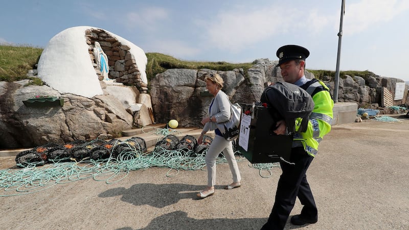 Garda Pat McIlroy and Nancy Sharkey, Presiding Officer for Gola Island, an island off the coast of Donegal, Ireland, arrive on the island with the ballot box as Islanders go to the polls. Brian Lawless/Press Association&nbsp;