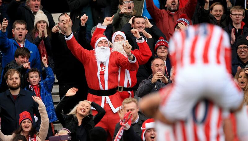 A fan dressed as Santa celebrates a Stoke goal