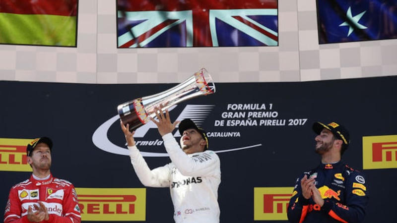 Mercedes driver Lewis Hamilton throws his trophy in the air after winning the Spanish Formula One Grand Prix at the Barcelona Catalunya racetrack in Montmelo, Spain today, Sunday, May 14 2017. <br />At left is second place, Ferrari driver Sebastian Vettel of Germany and right is third place Red Bull driver Daniel Ricciardo of Australia. &nbsp;